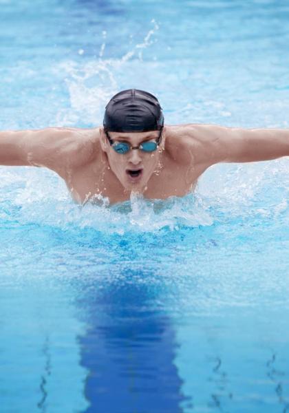 Nuotatore esegue stile farfalla in piscina.