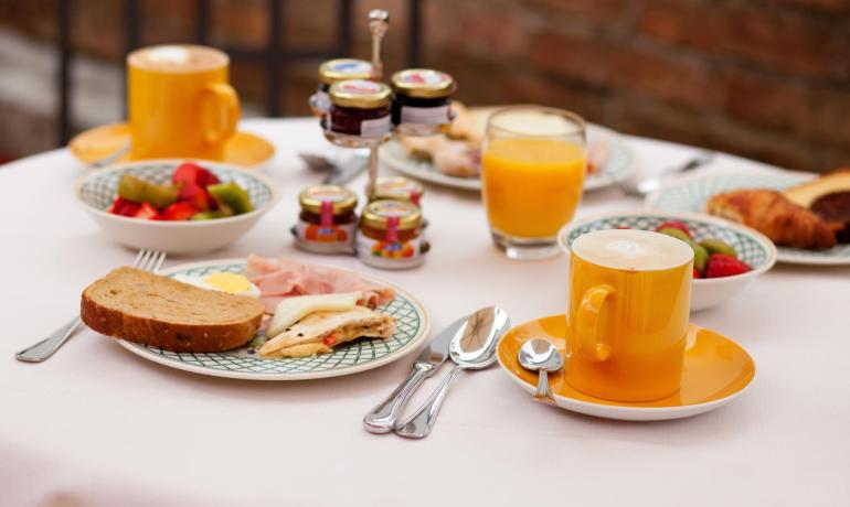 Colazione con pane, frutta, succo e caffè.