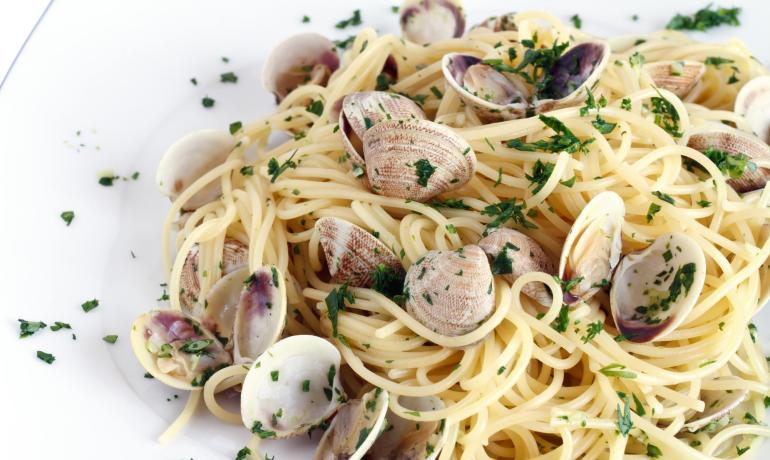 Spaghetti alle vongole con prezzemolo fresco.