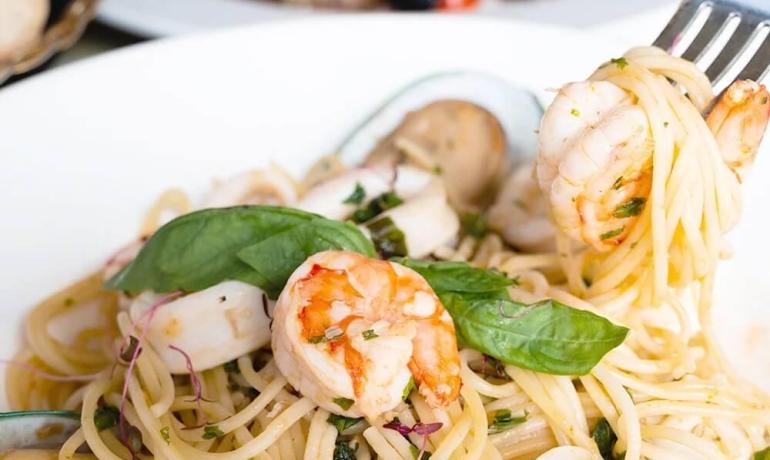 Spaghetti ai frutti di mare con gamberi e basilico fresco.